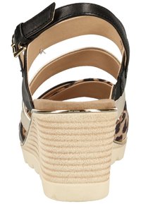 Black strappy sandal with a leopard print accent, a beige wedge heel featuring a textured surface, and an adjustable ankle strap with a metallic buckle.