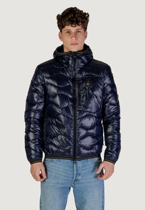 Giubbotto imbottito di un blu scuro, con chiusura a zip frontale, cappuccio e motivo testurizzato. Include una tasca sul petto e dettagli gialli sulla zip.