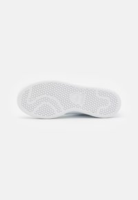 Vitt sneakersula med ett hexagonalt mönster för grepp, med en subtil vågdesign och Adidas-logotypen präglad på hälen.