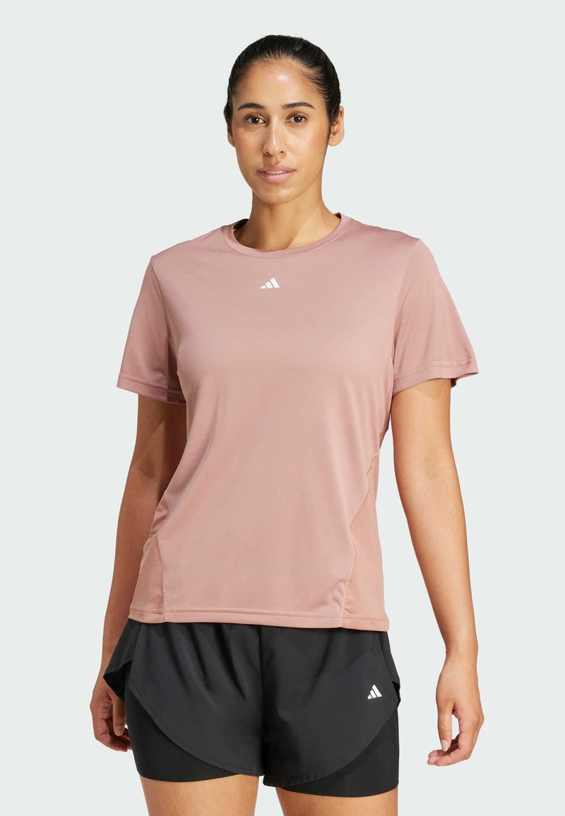 Rosa sporttröja med korta ärmar, rund halsringning och Adidas-logotyp; i kombination med svarta shorts med ett lagerdesign.