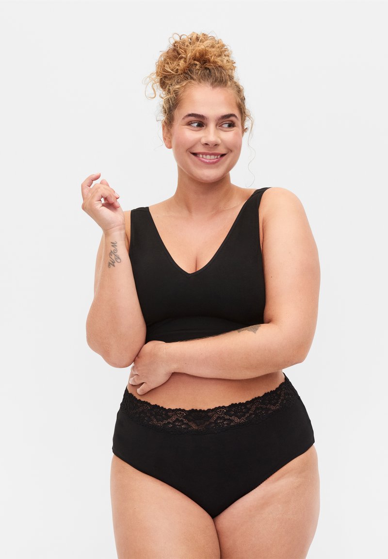 Zwart lingeriesetje met een V-hals bralette met brede bandjes en bijpassende hooggesneden panties versierd met kantafwerking. Zachte, rekbare stof.