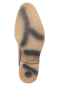 Semelle de chaussure brune avec une surface texturée, comportant un logo circulaire et le nom de la marque "bugatti" estampé. Légèrement usée avec des motifs distincts.