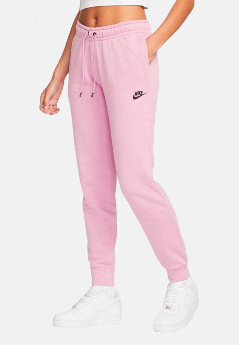 Rosa sweatsbyxor med ett elastiskt midjeband, snörning, sidofickor och en liten svart Nike-logga på vänstra låret. Matchas med vita sneakers.