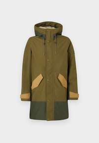 Parka vert olive avec doublure en fausse fourrure, accents beiges sur les poches et les poignets, capuche avec cordon de serrage et fermeture à boutons-pression. Matériau imperméable.