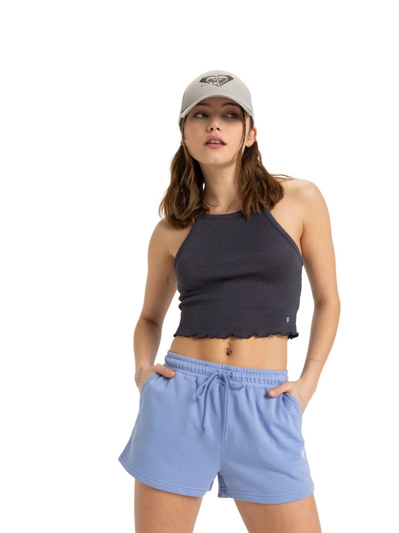 Top court côtelé gris foncé avec un ourlet en scallop associé à un short à cordon de serrage bleu clair. Le mannequin porte une casquette grise avec un logo brodé.