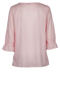 Roze katoenen top met driekwartmouwen en gerimpelde boorden. Bevat een subtiel verticaal gestreept patroon en een ronde halslijn.