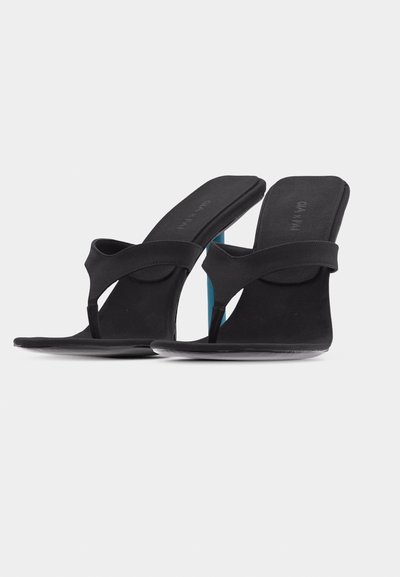 Μαύρες σανδάλες με λεπτό τακούνι, σχέδιο thong, με τετράγωνες μύτες, επενδυμένες σόλες και λεπτά λουράκια, τοποθετημένες πάνω σε απλό λευκό φόντο.