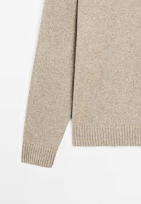 Beige trui met een zachte, gestructureerde brei, ribgebreide manchetten en zoom. Met een klassieke snit, lange mouwen en een ronde hals.