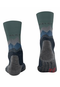 Calcetines verdes y marinos con un patrón de montañas; parte superior acanalada, talón y puntera reforzados, con tejido texturizado para mayor agarre. Marca: Falke.