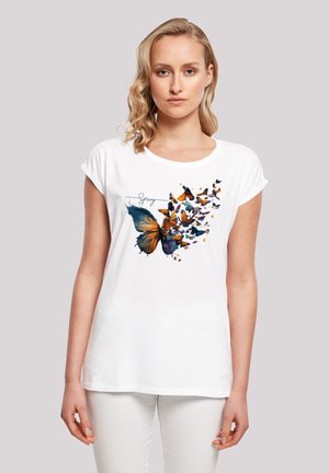 Weißes T-Shirt mit kurzen Ärmeln, das ein buntes Schmetterlingsmotiv in Orange und Blau sowie einen Textdetail "Frühling" zeigt. Glatte Textur.