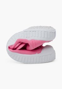 Pink folded shoe with a textured fabric upper, white rubber sole, and visible stitching details. Compact design for easy storage.