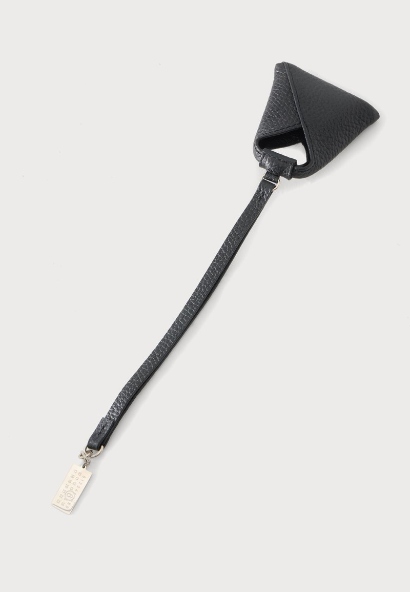 Housse de clé en cuir noir texturé avec une longue sangle et une petite étiquette métallique attachée à l'extrémité sur un fond clair.