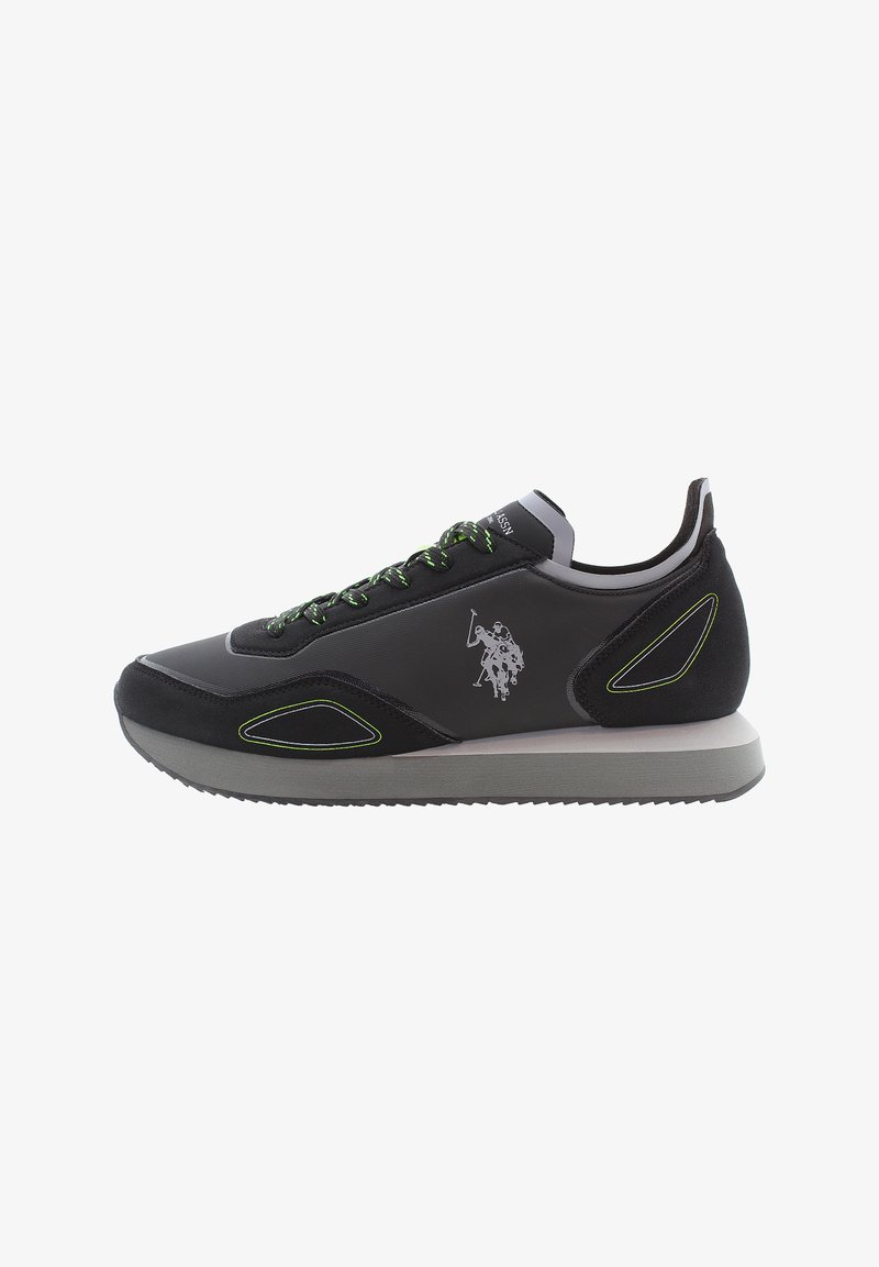 Chaussure de sport noire avec des lacets verts, tige en daim et synthétique, semelle en caoutchouc, détail de logo sur le côté et coutures d'accent.