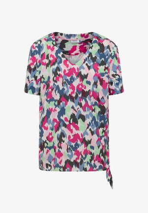 Haut à manches courtes avec col en V, motif abstrait multicolore rose, bleu, vert, noir et blanc et détail noué sur le côté.
