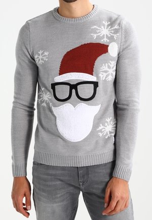 Mann trägt einen grauen Weihnachtspullover mit Weihnachtsmannmütze, Bart, schwarzen Brillen und weißen Schneeflockenmustern.