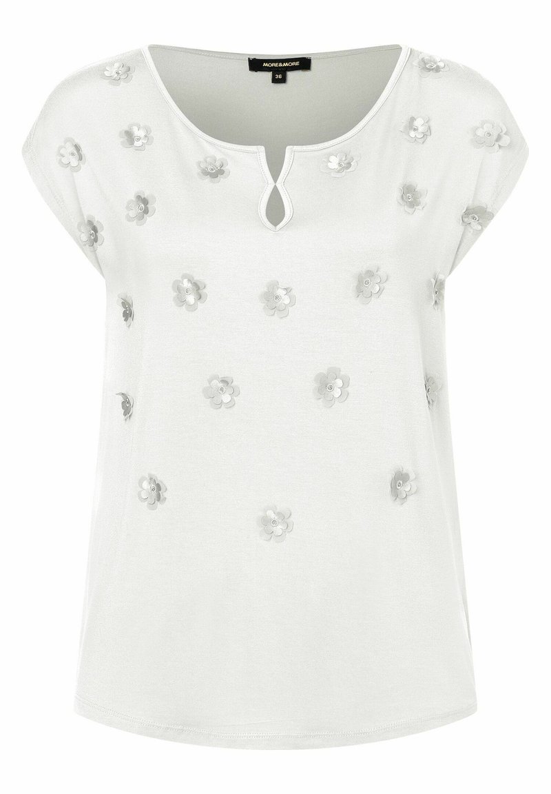 Blusa blanca de manga corta con escote en forma de keyhole y pequeñas aplicaciones de flores 3D distribuidas uniformemente en el frente y los hombros.