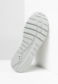 Semelle de chaussure en caoutchouc blanc avec un motif de grip texturé, nom de marque "NeroGiardini" en relief, et détail du drapeau italien près de l'indicateur de taille.