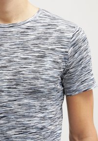 Krátký rukáv tričko vyrobené z lehkého materiálu, s melírovaným vzorem v odstínech modré, šedé a černé a kulatým výstřihem.