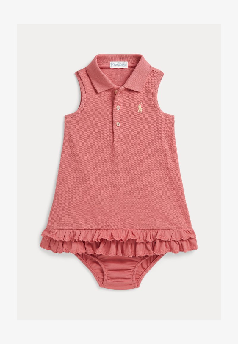 Μπλουζάκι μωρού ροζ χωρίς μανίκια με γιακά, τρία κουμπιά, λογότυπο στο στήθος και βολάν στο τελείωμα, πάνω από καλυπτήρα πάνας που ταιριάζει.