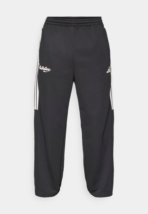 Mustad pehmete riietega spordipüksid, millel on valged küljeribad, elastne vöökoht ja tikitud logo ees.