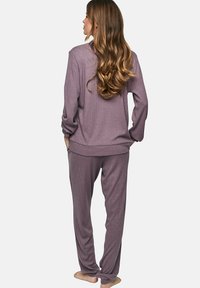 Paars geribbeld loungewear set met een losvallende langer mouw top en broek met elastische taille, met een zachte textuur en een ontspannen silhouet.