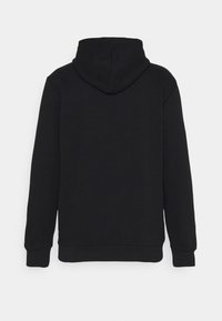 Juodas gobtuvas su ilgomis rankovėmis, raibais kraštais ir minkšta tekstūra. Pasižymi laisvu siluetu ir minimalizmu, be matomų logotipų.