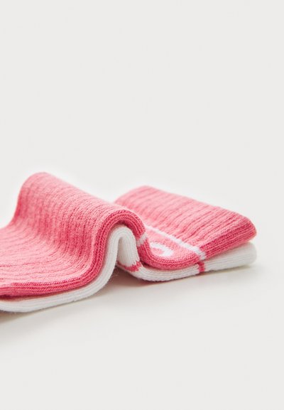 Chaussettes côtelées roses et blanches, avec un motif texturé, un design plié et une bande blanche contrastante. Matière en tricot douce.