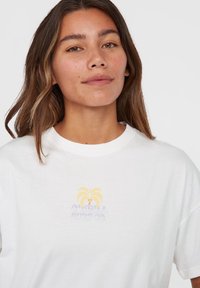 White cotton t-shirt featuring a graphic design with yellow and purple palm trees and text reading "O'Neill Surf Co." on the front.