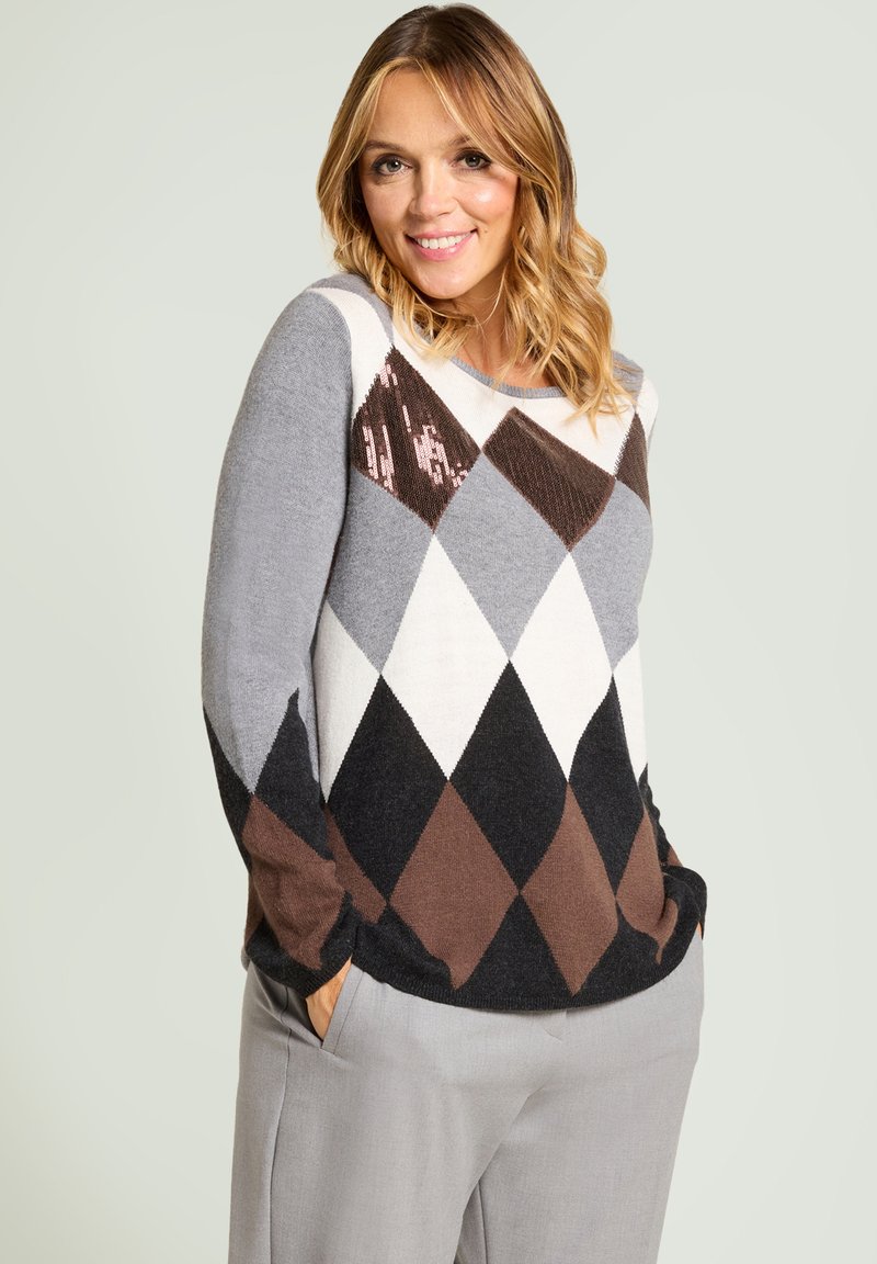 Suéter de patrón argyle en gris, negro y marrón, de tela de punto, con un ajuste relajado, cuello redondo y mangas largas. La modelo lleva pantalones grises.