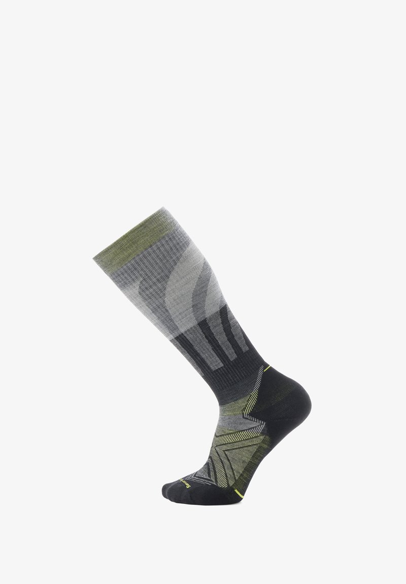 Calcetines hasta la rodilla con un patrón degradado en gris y verde, con un talón y punta negros. Tejido texturizado con acentos geométricos.