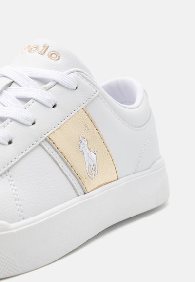 Vit sneakers i syntetiskt läder; har en beige panel med en broderad logotyp och vita snören; texturerad gummisula.