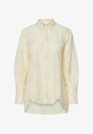 Lys gul knap-op skjorte med blomsterbroderi, lange ærmer, buet kant og tekstureret stof med et subtilt ternet mønster.