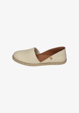Cream slip-on flat shoe with textured sole and open side detail, featuring a small leather tag on the outer edge.