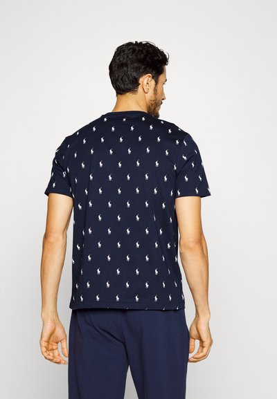 Tricou din bumbac de culoare bleumarin, cu un model repetitiv de logo alb cu jucător de polo, mâneci scurte și design cu gât rotund.