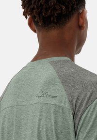 Camicia a maniche corte caratterizzata da una combinazione di colori verde e grigio, con una finitura testurizzata e un logo geometrico sulla parte superiore della schiena.