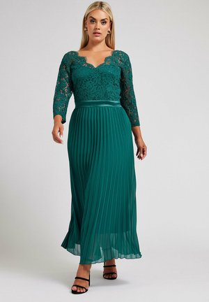 Teal pleated maxi dress with a lace bodice, three-quarter sleeves, and a satin waistband. Smooth texture and flowing silhouette.