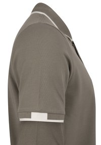 Camisa polo en verde oliva, con tejido texturizado y acentos blancos en el cuello y las mangas. Diseño clásico con una tapeta de tres botones.