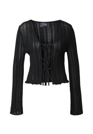 Black knit sweater with long sleeves, lace-up front, and ruffled hem. Features a textured, open weave pattern and V-neckline.