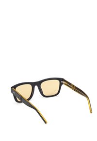 Occhiali da sole neri con lenti gialle sfumate. Il telaio presenta una finitura opaca, e le aste hanno un design elegante con una combinazione di colori nero e giallo.