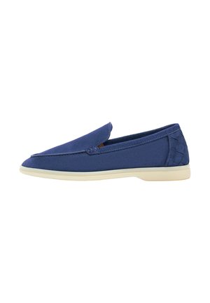 Mocassin homme bleu marine à enfiler avec une semelle beige et un détail talon texturé, présenté de profil sur un fond blanc.