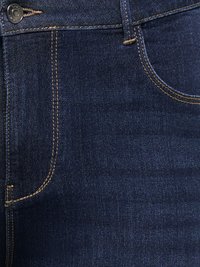 Lähikuva tummansinisistä farkuista, joissa näkyy vyötärönauha, etutasku ja oranssit tikkausyksityiskohdat.