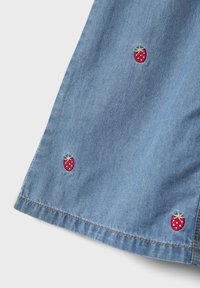 Denim tkanina svijetloplave boje s glatkom teksturom, s malim crvenim vezom jagoda na rubu. Kontrastno šivanje.