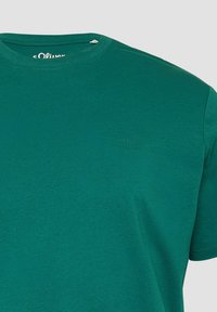Donkergroene t-shirt van zacht katoen, met een ronde hals en korte mouwen. Klein s.Oliver-logo op de borst gedrukt.