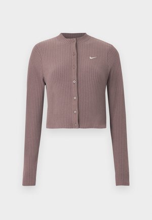 Haut court à manches longues côtelé de couleur mauve douce, avec un col rond et des boutons à l'avant. Présente un logo Nike blanc discret sur la poitrine.