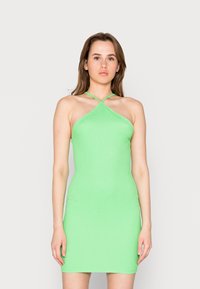 Vestido halter malha canelada verde com um formato ajustado. Apresenta alças cruzadas e um tecido liso e elástico.