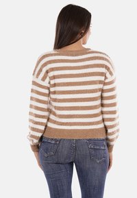 Maglione a righe con una morbida e pelosa texture in beige e bianco. Vestibilità classica con orlo inferiore a coste e scollatura rotonda. Design casual.