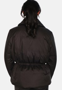 Svart boblejakke med innsnevret midje, høy krage og glatt, skinnende tekstur. Har et lett, isolert design.