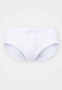 Vita simbyxor med en slät textur, utrustade med en framslips och sidöppningar. Tillverkade av elastiskt badklädesmaterial.