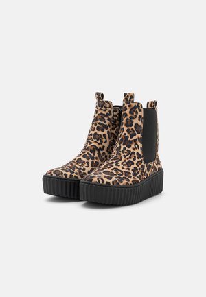 Robuste Plateau-Stiefeletten mit Leopardenmuster-Stoff und schwarzen elastischen Seitenpaneelen auf grauem Hintergrund.