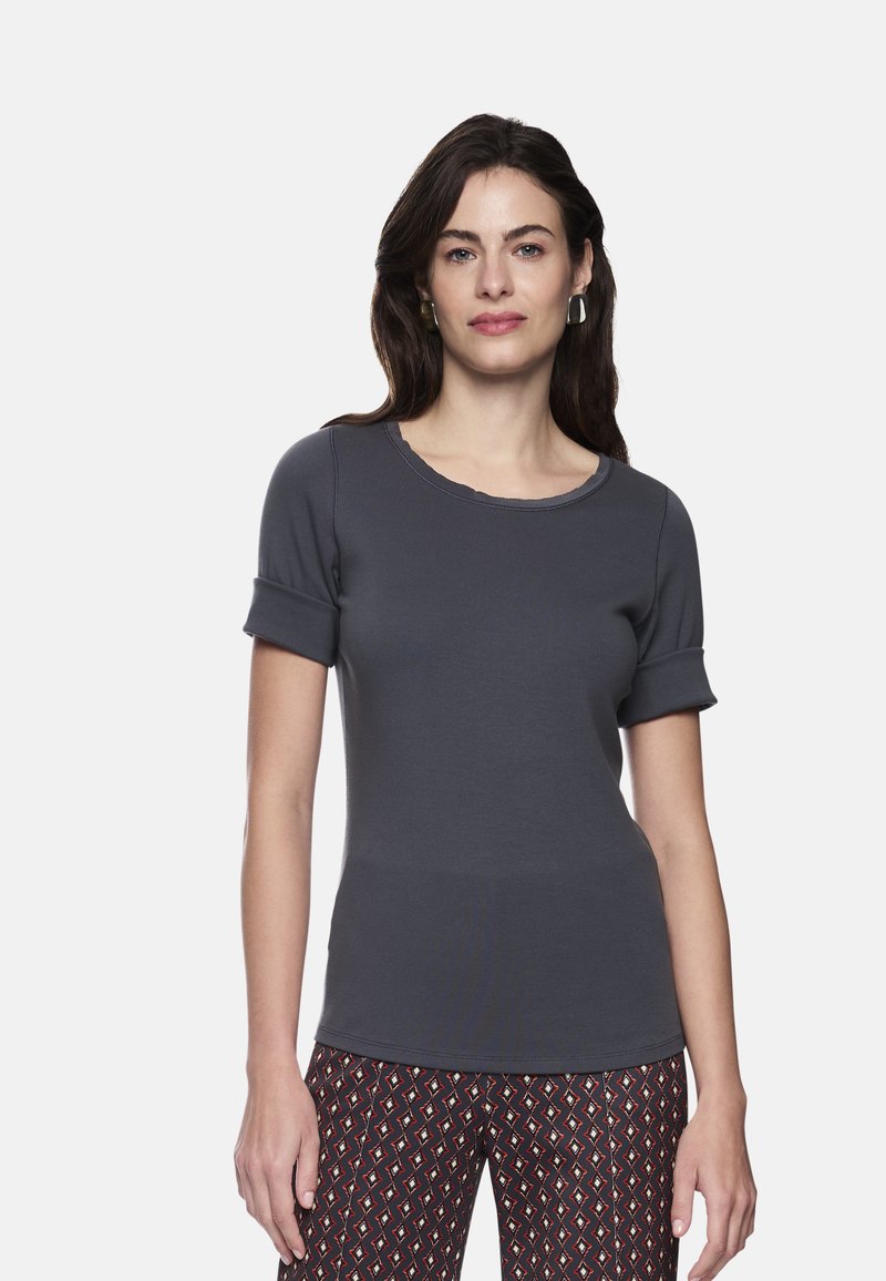 Graues T-Shirt mit kurzen Ärmeln, rundem Ausschnitt und aufgerollten Bündchen, aus weichem Stoff, kombiniert mit gemusterten Hosen mit geometrischem Design.